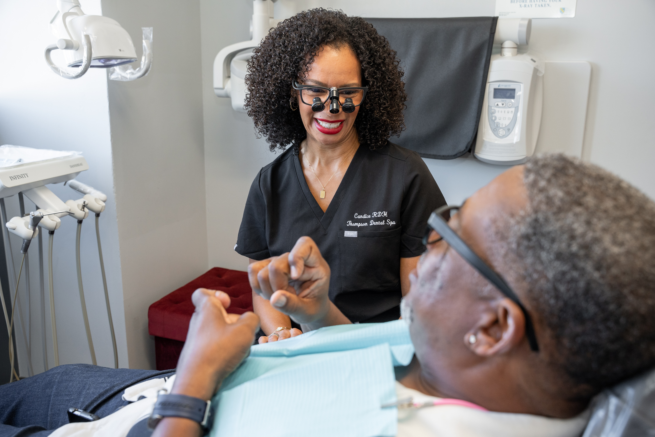 Candice Adams, Registered Dental Hygienist of Derrick Thompson DDS INC is smiling gracefully to an elderly patient - Dentist Los Angeles Candice Adams, Registered Dental Hygienist of Derrick Thompson DDS INC is smiling gracefully to an elderly patient - Dentist Los Angeles