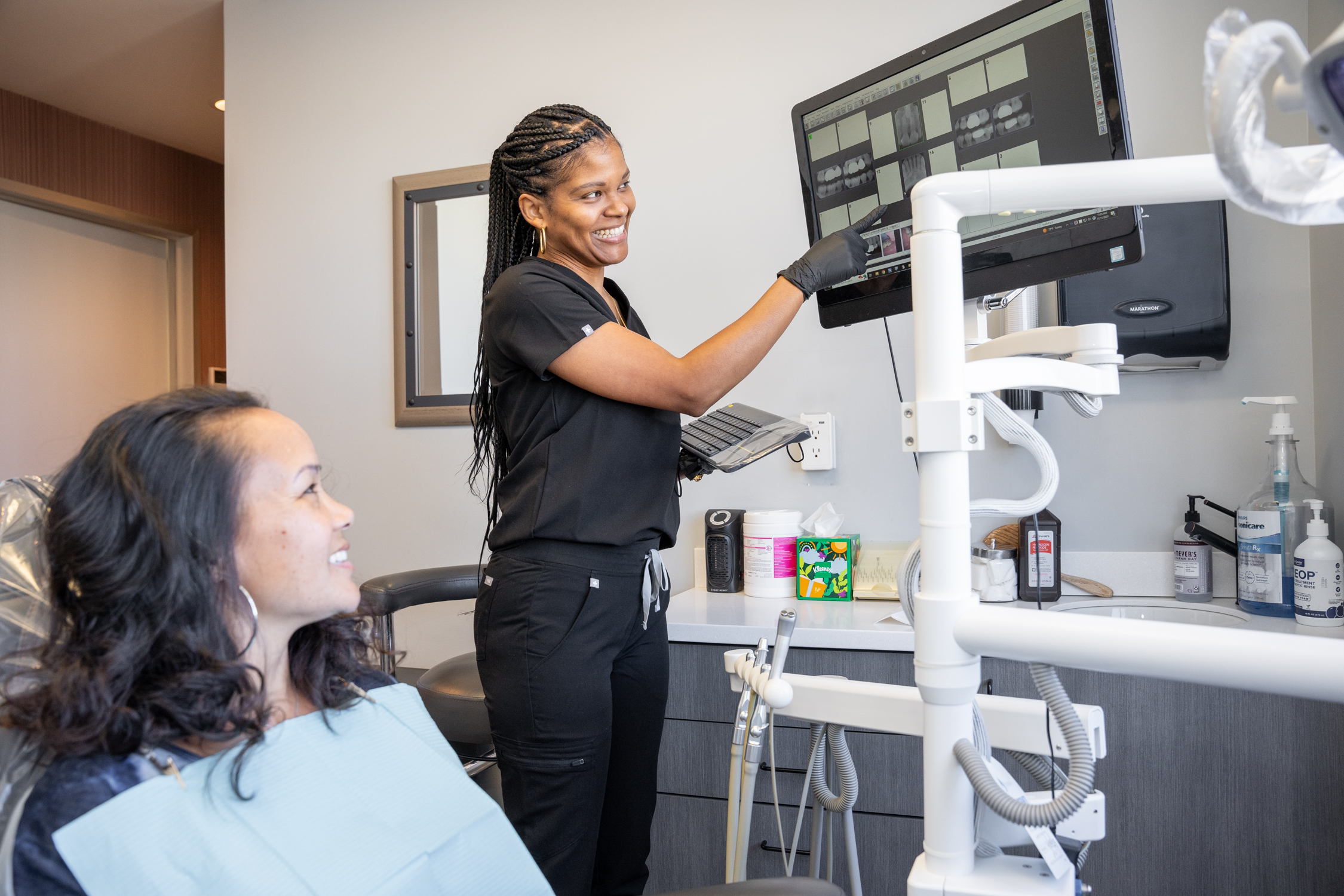 Dana L., a Registered Dental Assistant of Derrick Thompson DDS INC is showing scan results of teeth structure to a patient - Dentist Los Angeles Dana L., a Registered Dental Assistant of Derrick Thompson DDS INC is showing scan results of teeth structure to a patient - Dentist Los Angeles